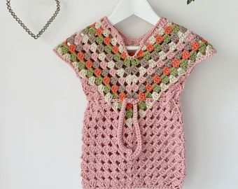 May include: A pink crocheted top with a colorful geometric pattern around the neckline and a tie at the waist.