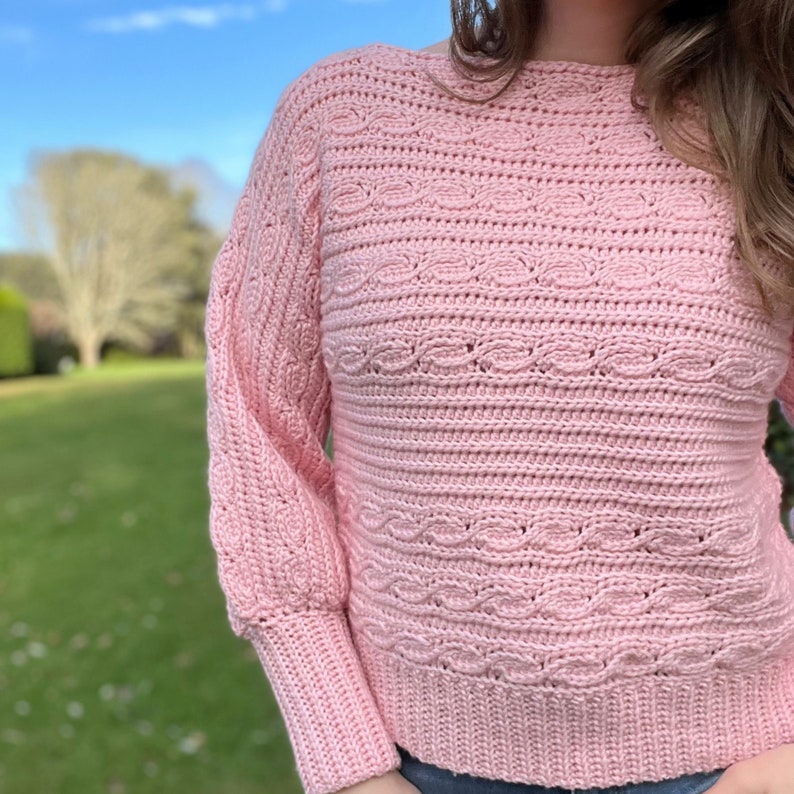 Close up of faux cable crochet pattern on sweater with long arm cuffs.