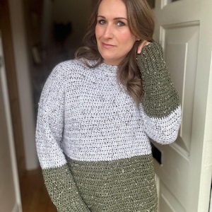 Puede incluir: Un su&eacute;ter de crochet verde y blanco con textura brillante. El su&eacute;ter tiene mangas largas y cuello redondo.