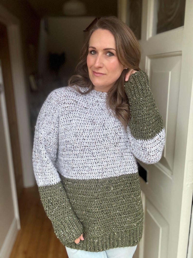 Puede incluir: Un su&eacute;ter de crochet verde y blanco con textura brillante. El su&eacute;ter tiene mangas largas y cuello redondo.