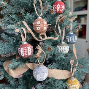 A collection of crochet Christmas baubles on a fir christmas tree.