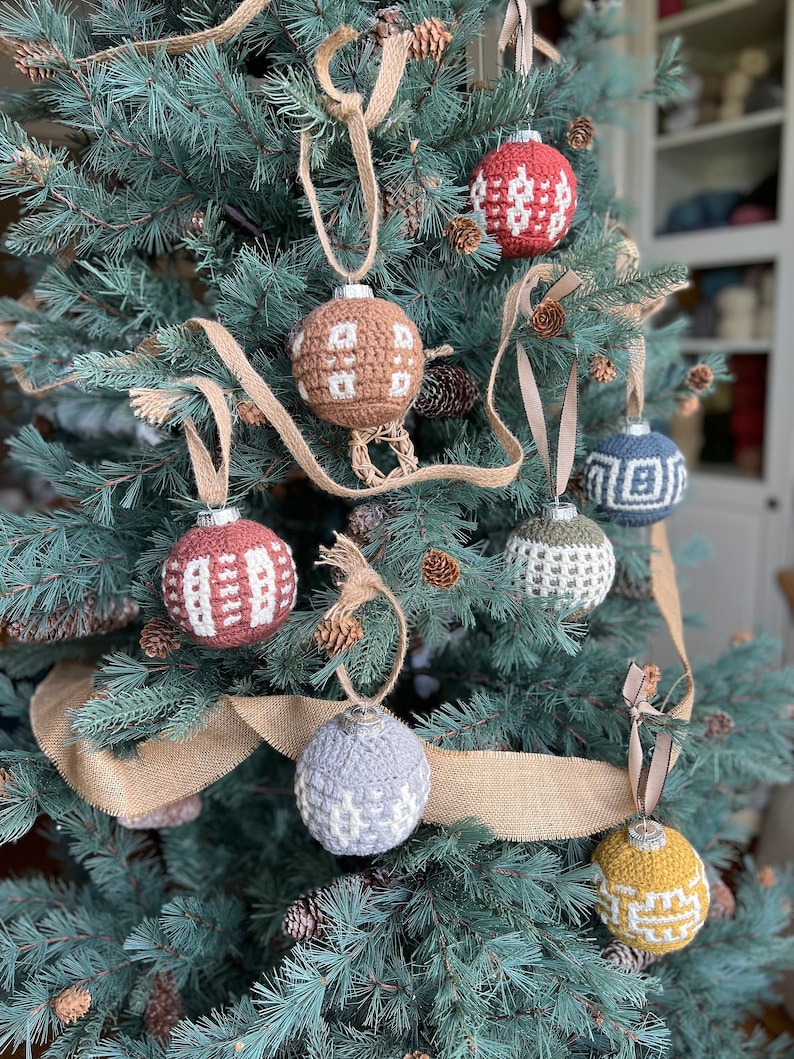 A collection of crochet Christmas baubles on a fir christmas tree.