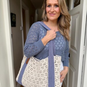 Puede incluir: Un su&eacute;ter de manga larga de ganchillo azul con escote cuadrado y patr&oacute;n calado, combinado con un bolso grande con cuerpo de ganchillo color crema, asas de ganchillo azules y paneles laterales azules con una peque&ntilde;a leng&uuml;eta de cuero marr&oacute;n.