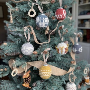 A collection of crochet Christmas baubles on a fir christmas tree.