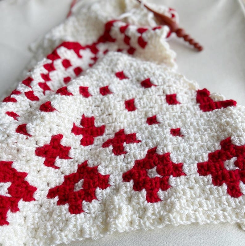 Close up of white and red yarn with a crochet hook.