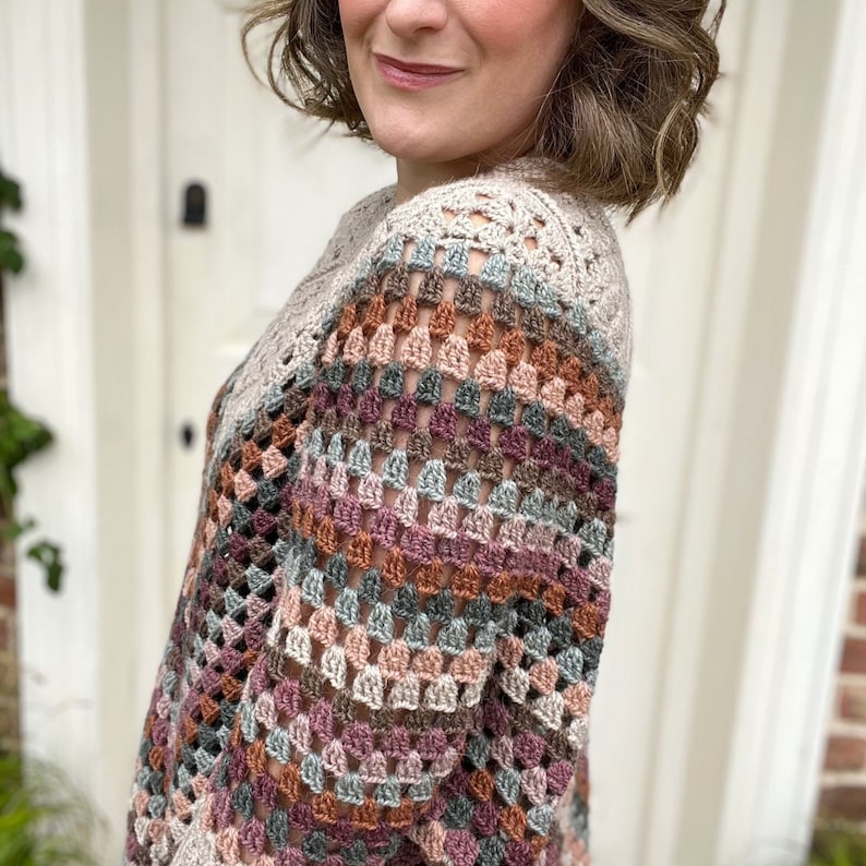 Puede incluir: Un top de crochet multicolor con un corte holgado y un escote amplio. El top est&aacute; hecho con una variedad de tonos de hilo marr&oacute;n, rosa y azul.