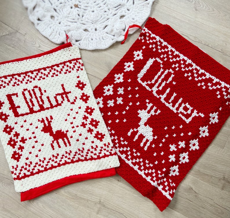 Two red and white crocheted christmas blankets. Each has a name and a reindeer on it.