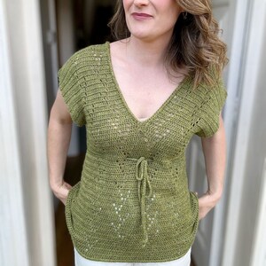 Puede incluir: Un top de crochet verde con cuello en V y un lazo en la cintura.