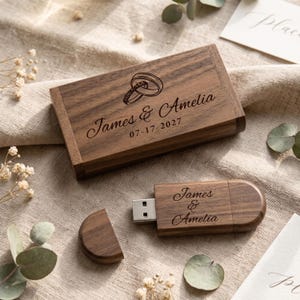 Peut inclure: Une boîte rectangulaire en bois foncé et une clé USB en bois assortie. Le couvercle de la boîte est gravé avec deux anneaux entrelacés, les noms James & Amelia et la date 07-17-2027. La clé USB est gravée avec les noms James & Amelia.