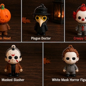 May include: Five small horror-themed keychains featuring a Pumpkin Head, a Plague Doctor in a black coat, a Creepy Clown with red hair, a Masked Slasher with a hockey mask, and a White Mask Horror Figure, each with a silver ball chain attached.