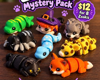 May include: A collection of eight articulated 3D printed mini creatures labeled Zookis Mystery Pack. The figures include a green lizard, a witch, a gray wolf, a black spider, a blue snake, a yellow giraffe, a black cat, and an orange fox.