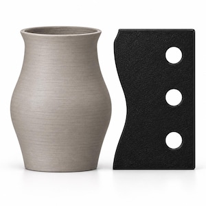 May include: A light gray, tapered vase with a smooth, matte finish alongside a rectangular black tool featuring a wavy side edge and three circular cutouts arranged vertically. Both items are positioned upright on a plain white surface.