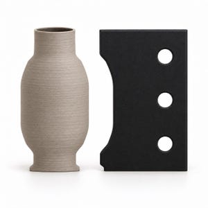 May include: A light beige vase with a textured, horizontal-lined surface and a narrow neck, positioned next to a rectangular black object featuring a curved side edge and three circular cutouts arranged in a vertical line.