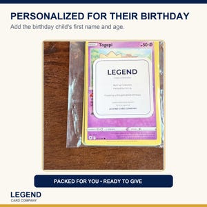 Puede incluir: Una carta coleccionable de Togepi dentro de una funda de pl&aacute;stico transparente con una etiqueta cuadrada blanca en el frente. La etiqueta presenta el texto LEGEND CARD COMPANY, Built by Collectors, Packed by Family, Creating unforgettable birthdays y Find us again at LEGEND CARD COMPANY.