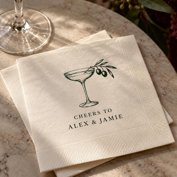 Cocktail napkin printed with a drawn coupe glass and Cheers to Alex and Jamie