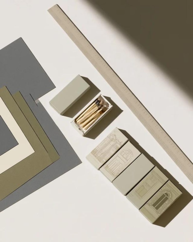 Cream rectangular drawer-style matchbox mockups arranged with coordinating neutral paper samples. The presentation shows sleeves, trays and the compact box proportions for bespoke event designs.