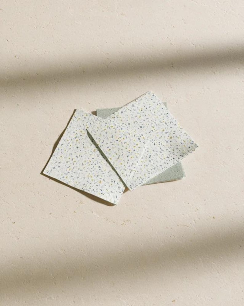 Square cocktail-napkin and paper-detail mockups with fine botanical line illustrations, styled with coordinating paper pieces. Digital presentation of a custom illustrated wedding and event design.