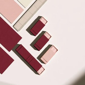 Contemporary matchbox mockup with a coloured paper sleeve and a clean graphic layout. The rectangular box is presented in soft directional light as a personalised wedding or event favour concept.
