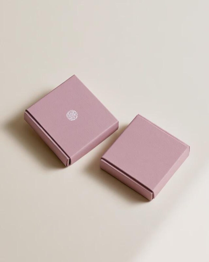 Contemporary matchbox mockup with a coloured paper sleeve and a clean graphic layout. The rectangular box is presented in soft directional light as a personalised wedding or event favour concept.