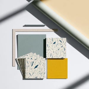 Square cocktail-napkin and paper-detail mockups with fine botanical line illustrations, styled with coordinating paper pieces. Digital presentation of a custom illustrated wedding and event design.