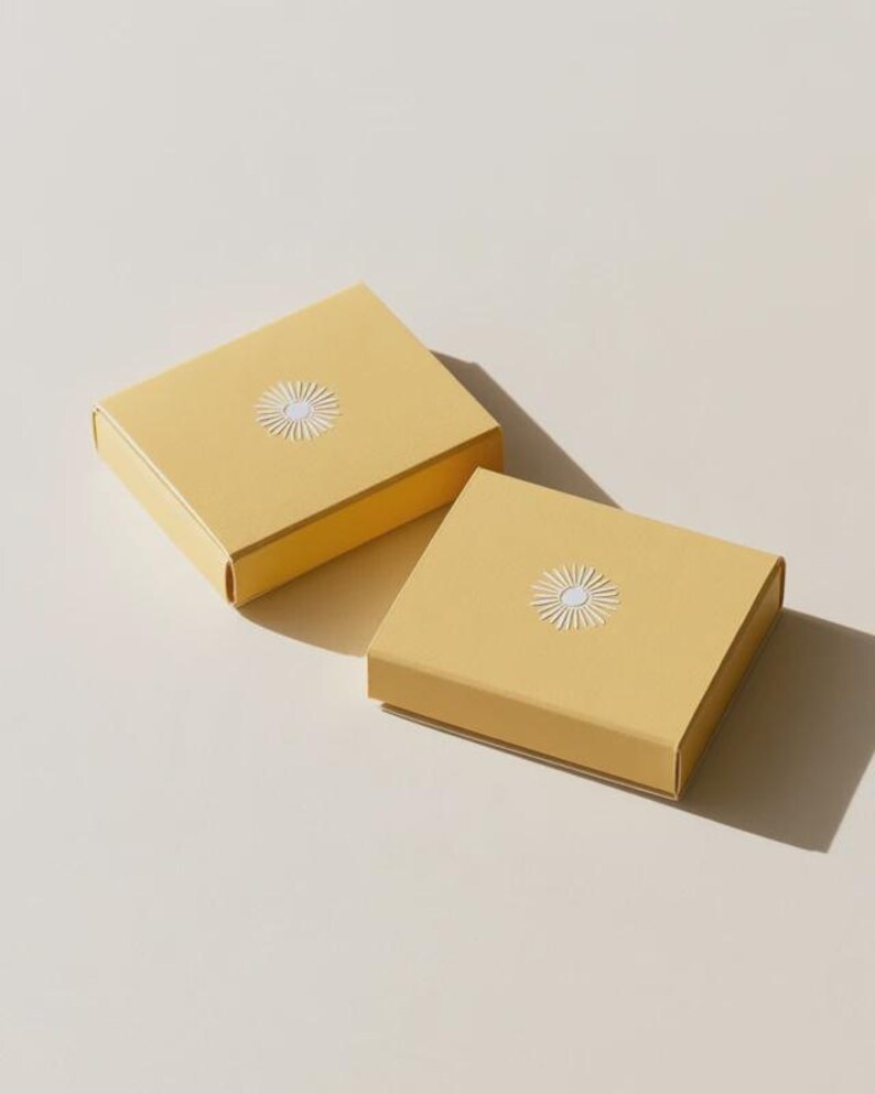 Contemporary matchbox mockup with a coloured paper sleeve and a clean graphic layout. The rectangular box is presented in soft directional light as a personalised wedding or event favour concept.