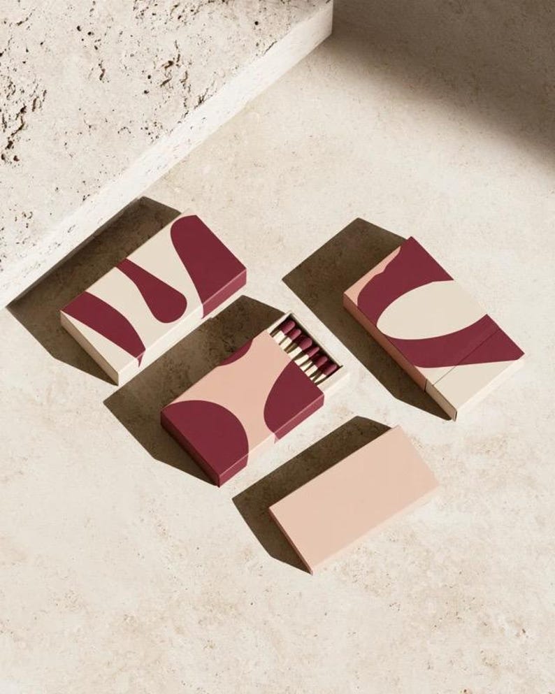 Burgundy and blush matchboxes with bold cut-out shapes