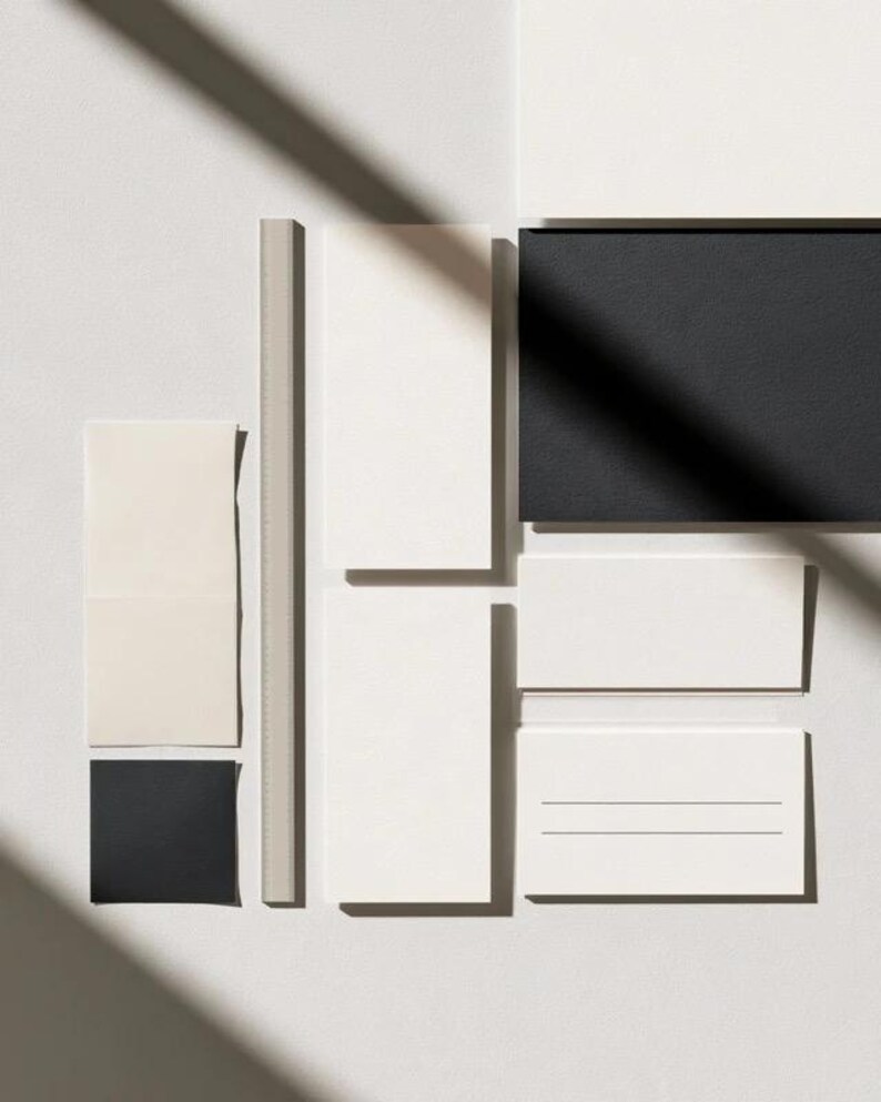 Cream rectangular menu cards and coordinated paper stationery arranged on a neutral background. Fine dark typography and generous margins create a restrained formal table-setting design. Digital concept mockup.