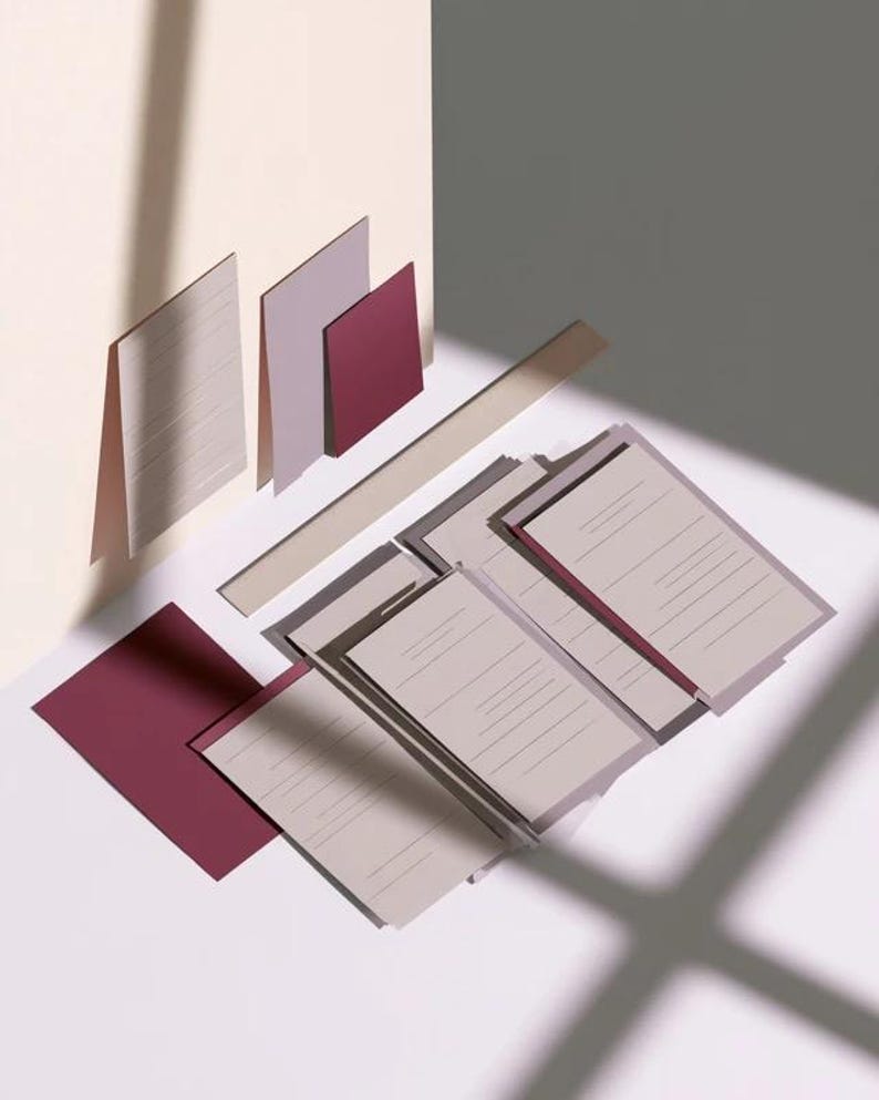 Layered unprinted menu-card mockups with curved paper edges in cream and muted burgundy tones. The arrangement shows contrasting paper shapes and soft shadows for a modern table-stationery design.