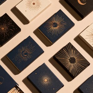 Dark matchbox mockups styled for an evening celebration, with plain and gold-toned decorative sleeve designs. The presentation shows compact rectangular boxes for personalised party favours.