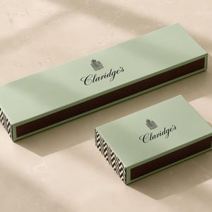 Concept mockup of jade matchboxes in 28cm and 14.5cm formats, with black Claridge’s branding and chevron ends.