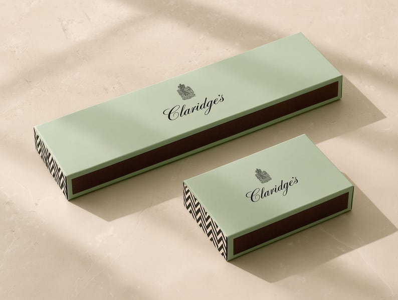 Concept mockup of jade matchboxes in 28cm and 14.5cm formats, with black Claridge’s branding and chevron ends.