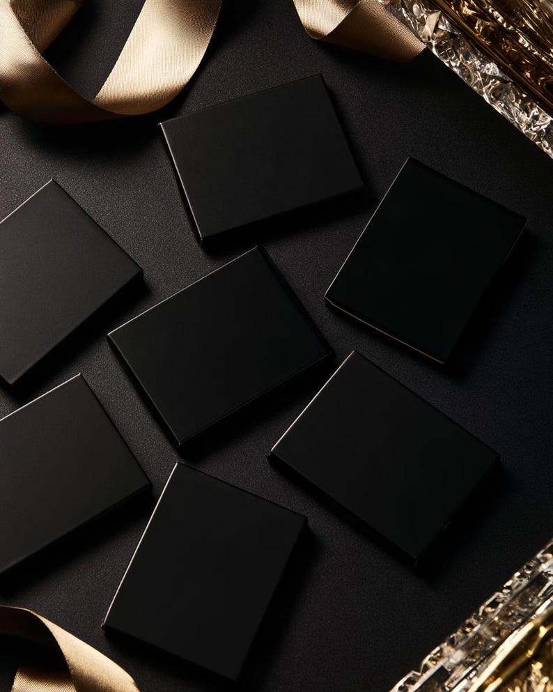 Dark matchbox mockups styled for an evening celebration, with plain and gold-toned decorative sleeve designs. The presentation shows compact rectangular boxes for personalised party favours.
