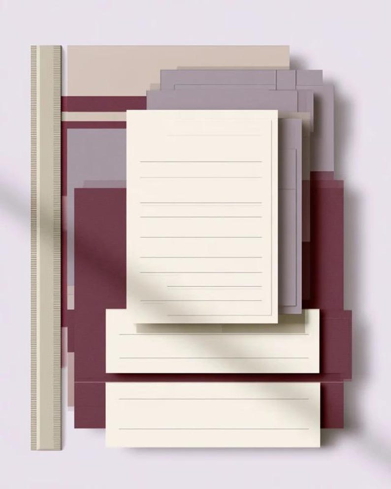Layered unprinted menu-card mockups with curved paper edges in cream and muted burgundy tones. The arrangement shows contrasting paper shapes and soft shadows for a modern table-stationery design.