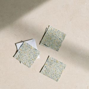 Square cocktail-napkin and paper-detail mockups with fine botanical line illustrations, styled with coordinating paper pieces. Digital presentation of a custom illustrated wedding and event design.