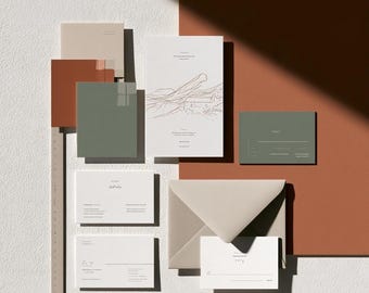May include: A stationery set featuring white, sage green, and terracotta cards and envelopes. The main card displays a line drawing of a landscape. A beige L-shaped ruler is positioned along the left and bottom edges, showing measurements in centimeters.