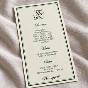 Może przedstawiać: Prostokątna karta menu z kremowym tłem i ciemnozieloną obw&oacute;dką z podw&oacute;jną linią. Tekst zawiera nagł&oacute;wki The Menu, Starters, Main i Sides, wymieniając r&oacute;żne potrawy, takie jak Prawn Salad, Kobe Beef oraz Edamame Mashed Potato.