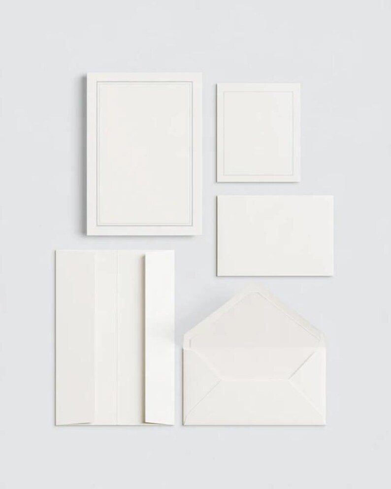 Unprinted cream invitation cards in several rectangular sizes with matching envelopes, arranged on a pale background. The mockup shows a coordinated wedding invitation, reply card and details-card format.