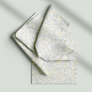 Square cocktail-napkin and paper-detail mockups with fine botanical line illustrations, styled with coordinating paper pieces. Digital presentation of a custom illustrated wedding and event design.