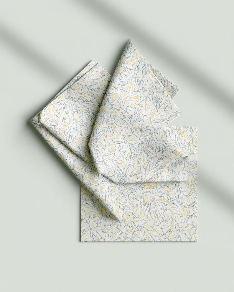 Square cocktail-napkin and paper-detail mockups with fine botanical line illustrations, styled with coordinating paper pieces. Digital presentation of a custom illustrated wedding and event design.