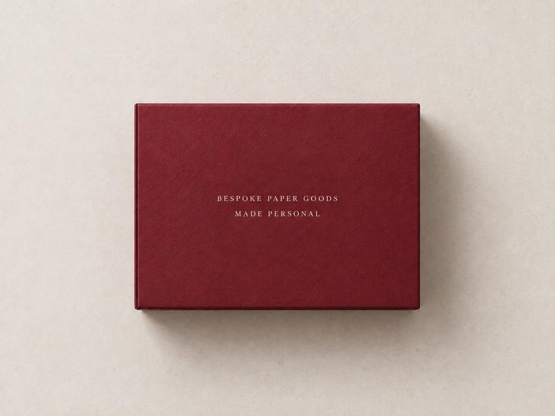 AI-assisted studio illustration of the reverse of the burgundy 14.5 cm matchbox, with ivory sample wording: Bespoke Paper Goods, Made Personal.