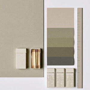 Cream rectangular drawer-style matchbox mockups arranged with coordinating neutral paper samples. The presentation shows sleeves, trays and the compact box proportions for bespoke event designs.