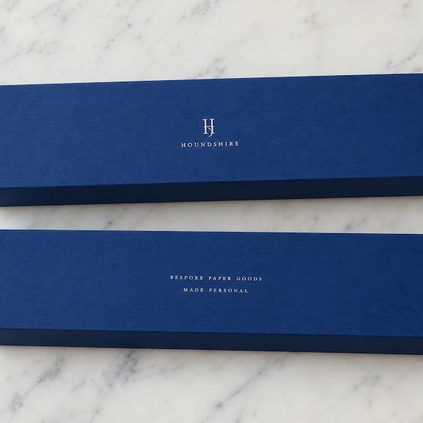 Long navy matchboxes printed with a small monogram