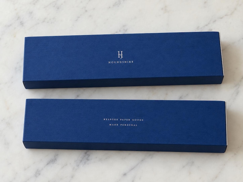 Long navy matchboxes printed with a small monogram