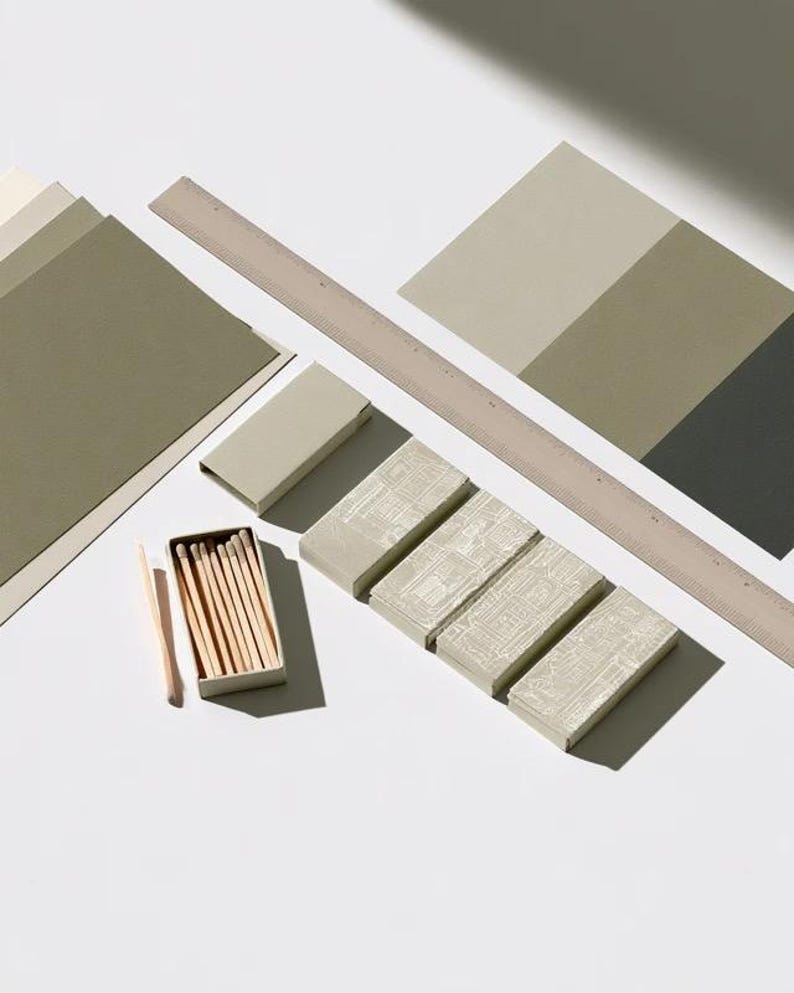 Cream rectangular drawer-style matchbox mockups arranged with coordinating neutral paper samples. The presentation shows sleeves, trays and the compact box proportions for bespoke event designs.