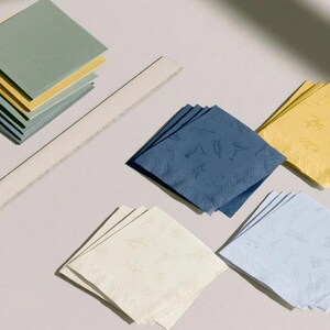 Square cocktail-napkin and paper-detail mockups with fine botanical line illustrations, styled with coordinating paper pieces. Digital presentation of a custom illustrated wedding and event design.