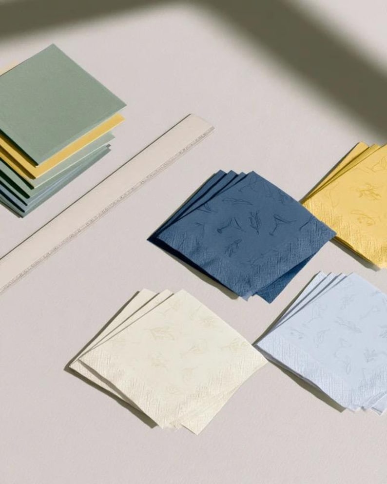 Square cocktail-napkin and paper-detail mockups with fine botanical line illustrations, styled with coordinating paper pieces. Digital presentation of a custom illustrated wedding and event design.