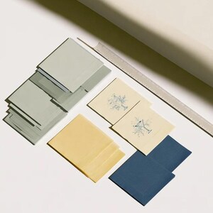 Square cocktail-napkin and paper-detail mockups with fine botanical line illustrations, styled with coordinating paper pieces. Digital presentation of a custom illustrated wedding and event design.