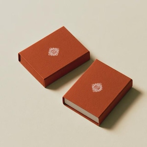 Contemporary matchbox mockup with a coloured paper sleeve and a clean graphic layout. The rectangular box is presented in soft directional light as a personalised wedding or event favour concept.