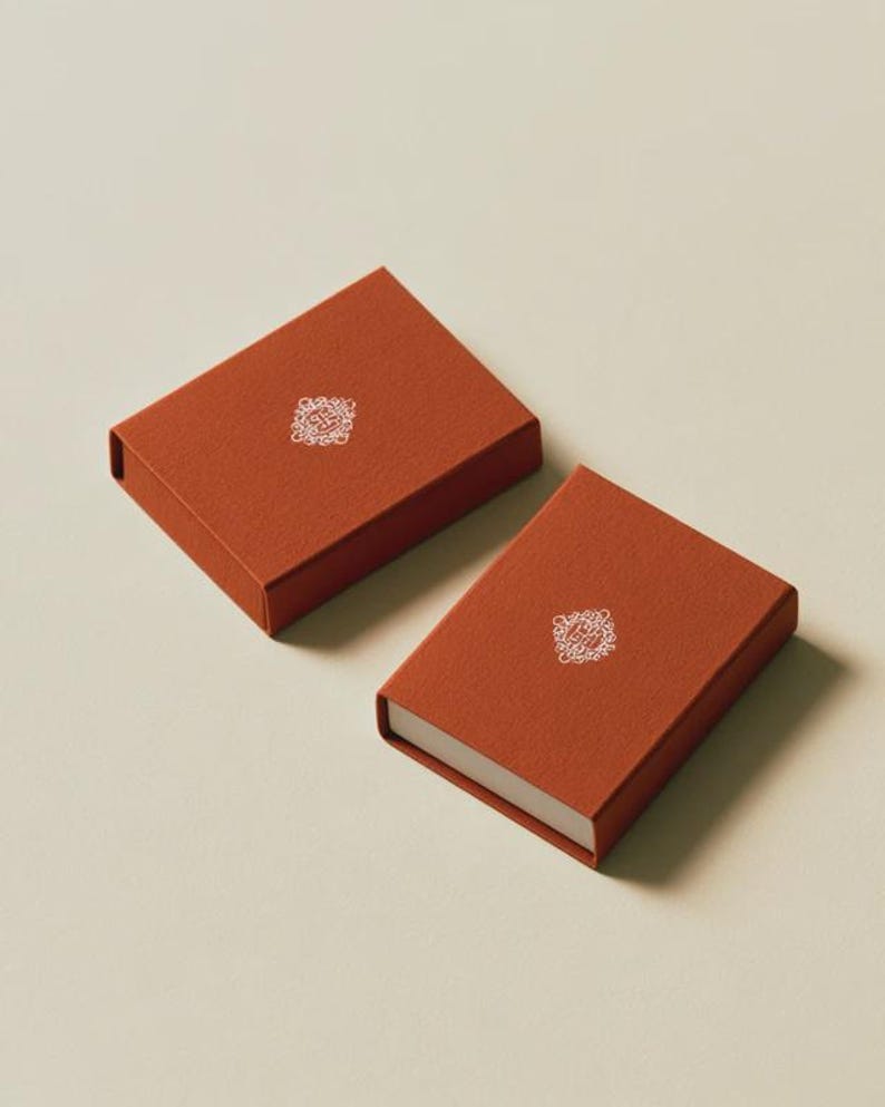 Contemporary matchbox mockup with a coloured paper sleeve and a clean graphic layout. The rectangular box is presented in soft directional light as a personalised wedding or event favour concept.