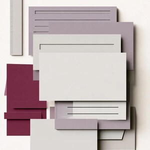 Layered unprinted menu-card mockups with curved paper edges in cream and muted burgundy tones. The arrangement shows contrasting paper shapes and soft shadows for a modern table-stationery design.